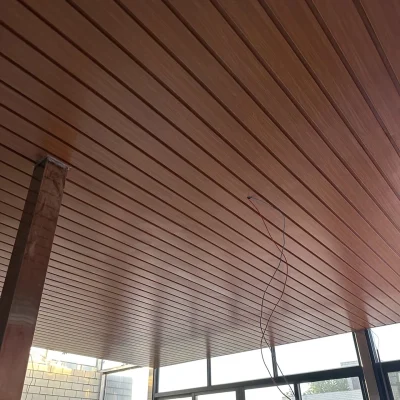 Installed aluminium ceiling strip panel in red wood grain finish